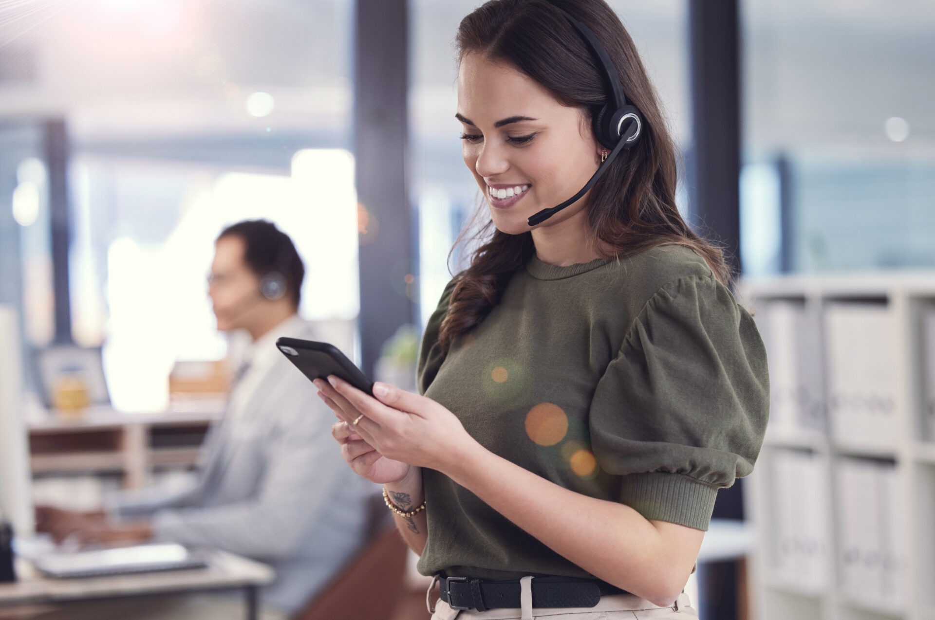 woman phone headset with microphone callcenter customer care with smile positivity female person consultant agent telecommunication company workplace technology